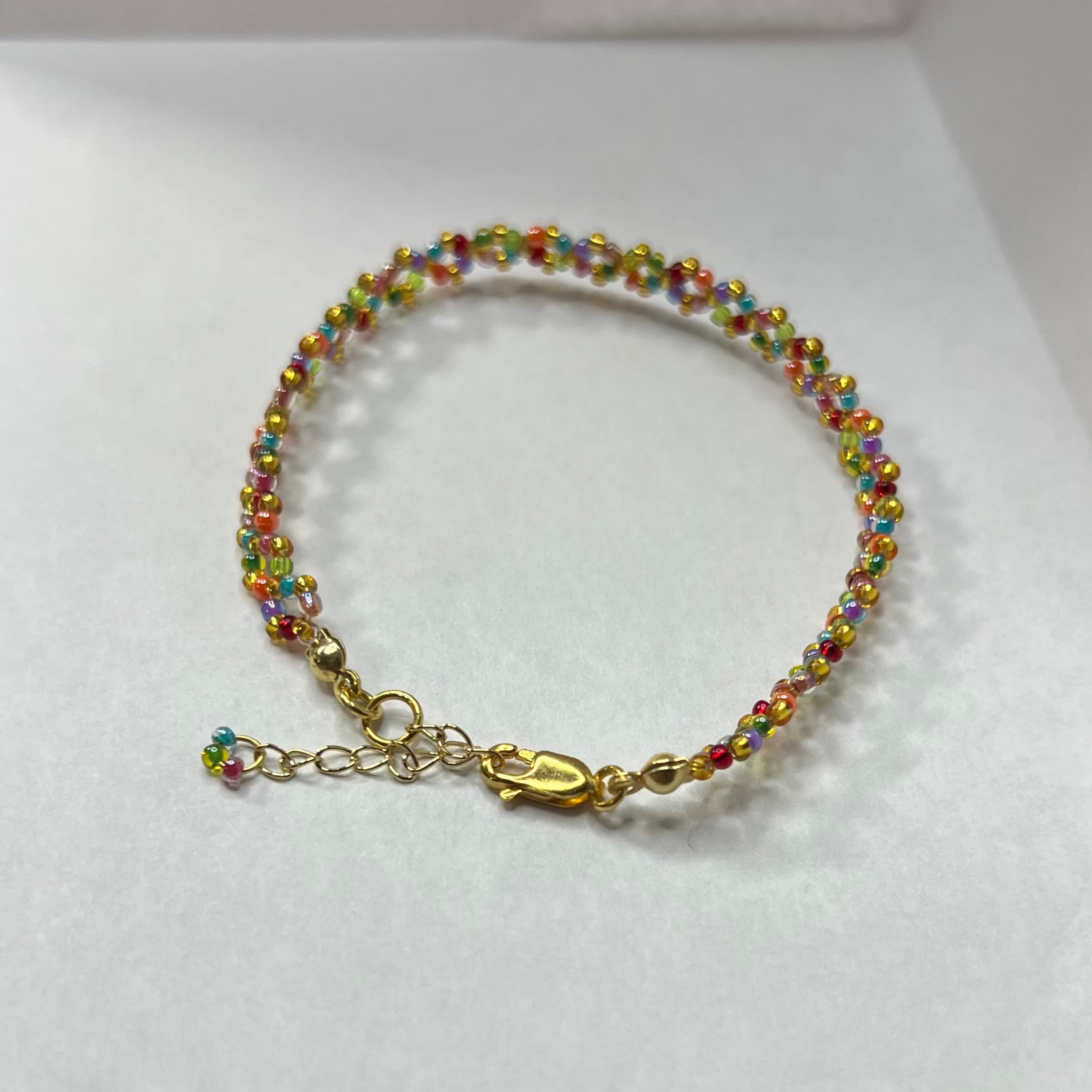 Colorful beaded bracelet on a white surface