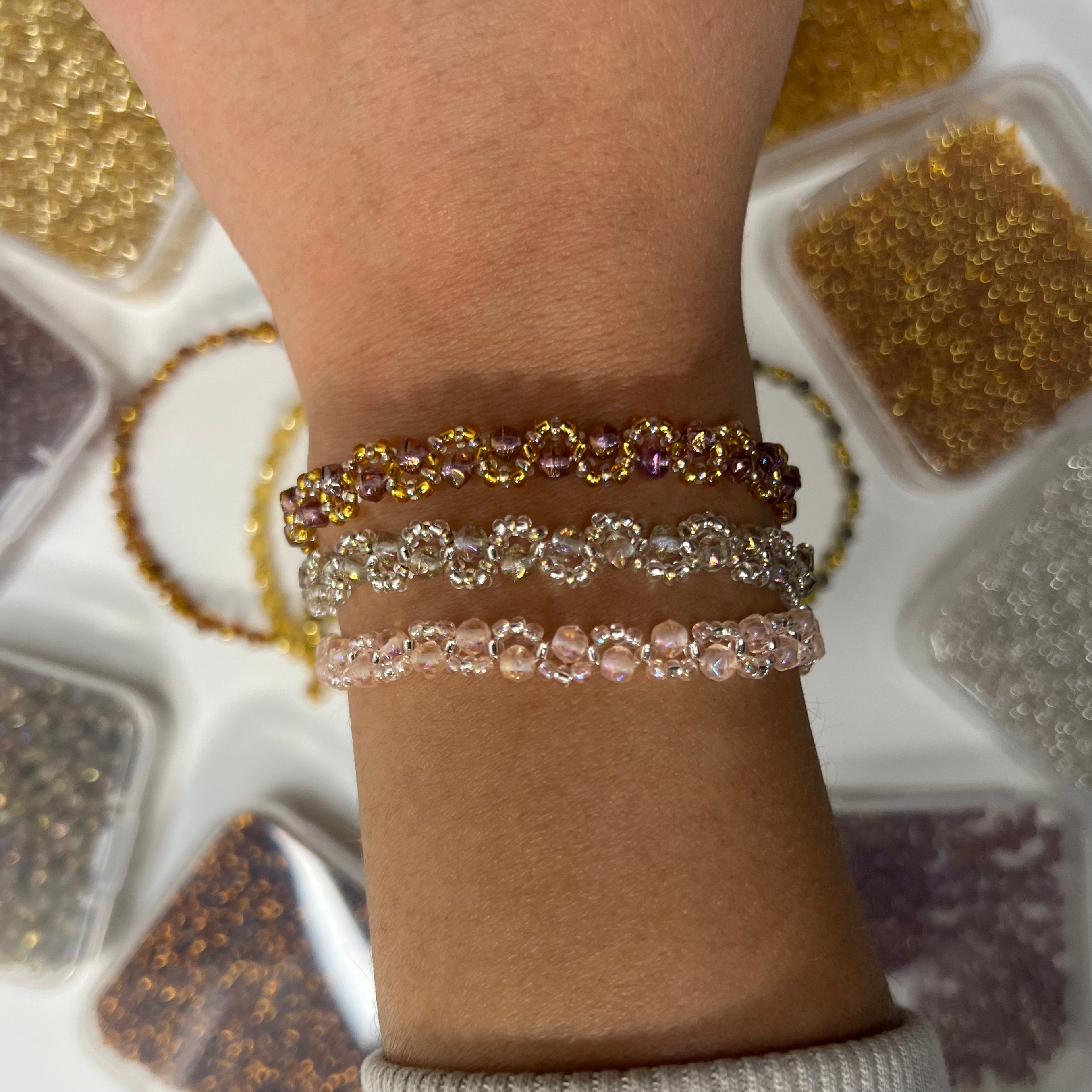 Close-up of a wrist wearing multiple beaded bracelets with a blurred background
