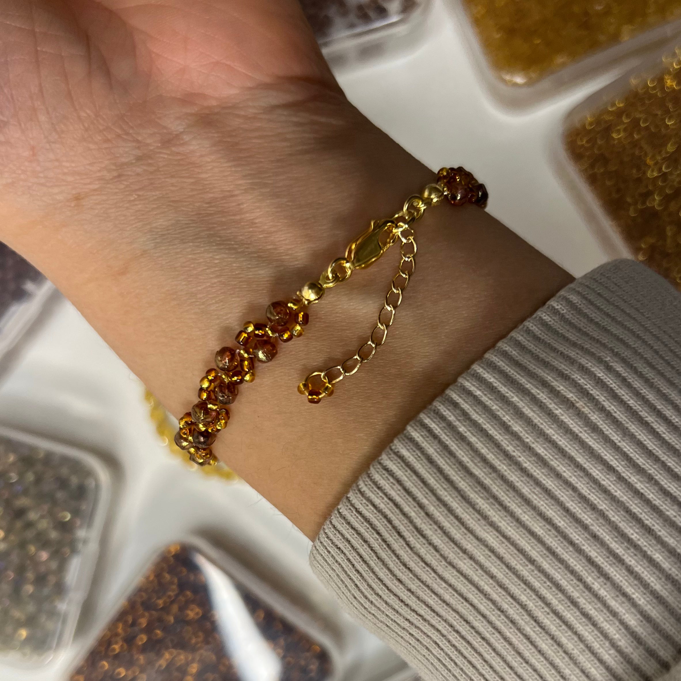 Gold bracelet on a wrist with a neutral background