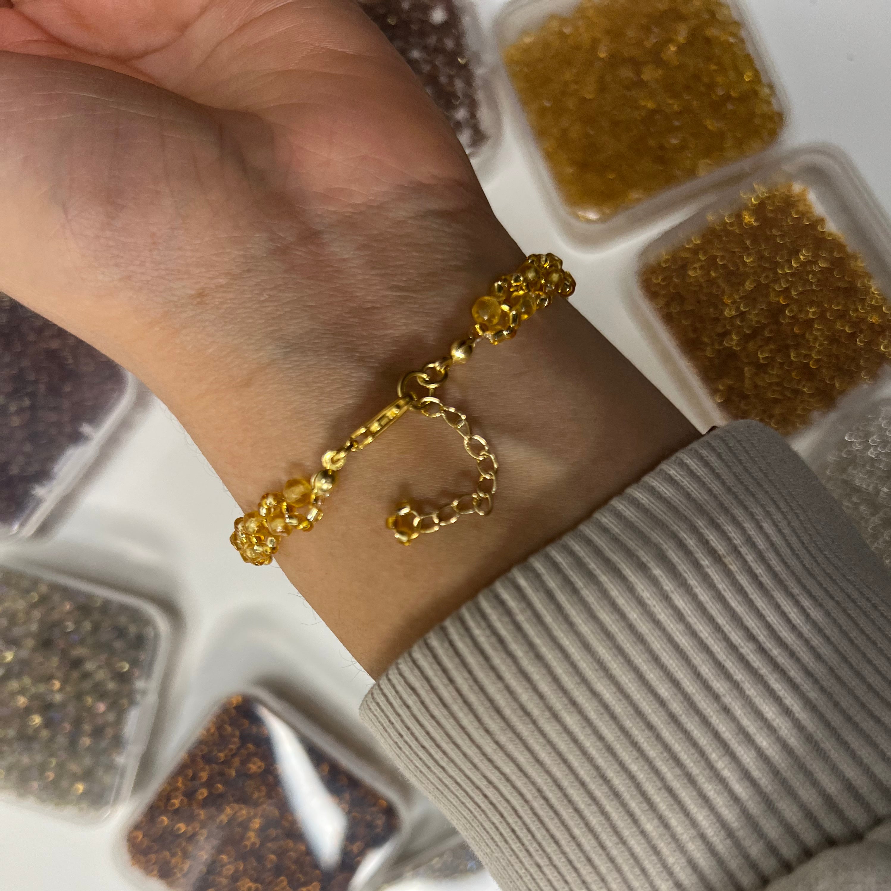 Gold bracelet on a wrist with a neutral background