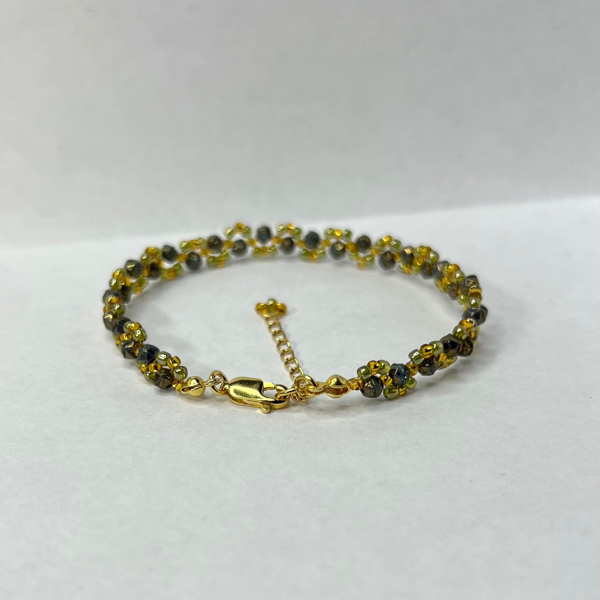 Bracelet with gold and dark beads on a white background