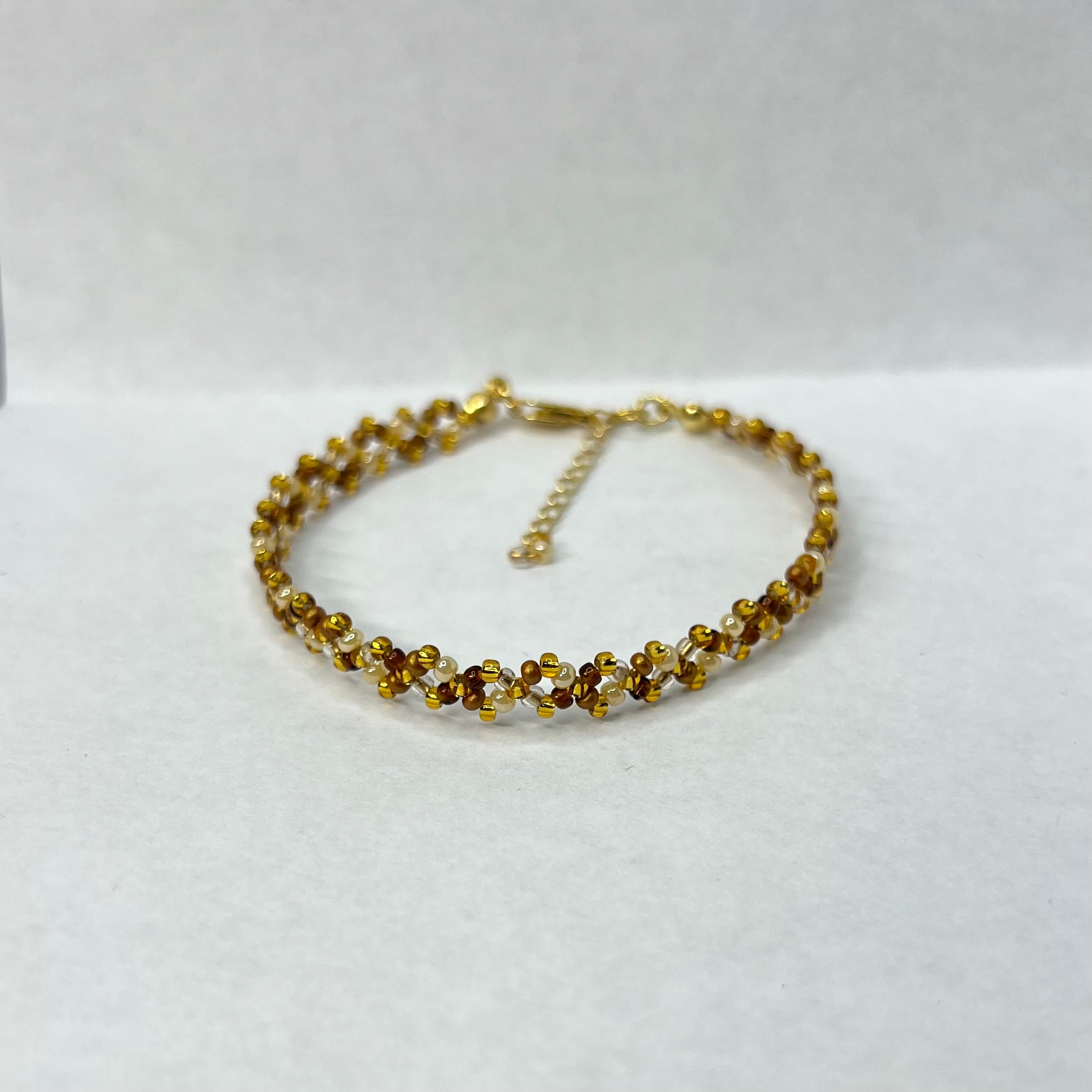 Gold beaded bracelet on a white background