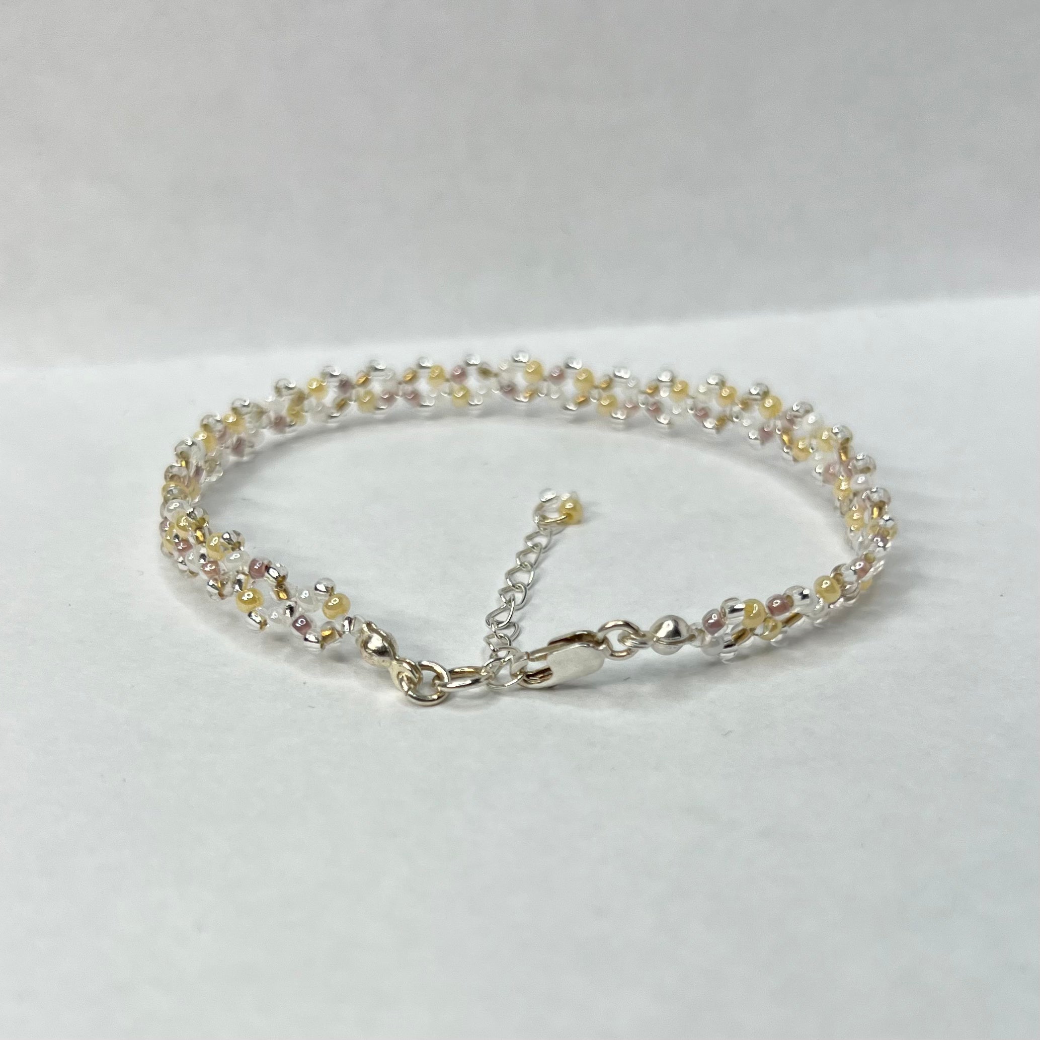 Silver bracelet with small beads on a white background