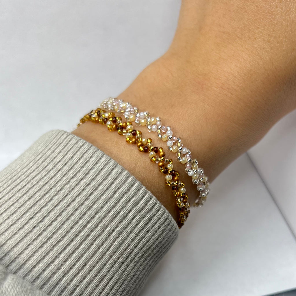 Close-up of a wrist wearing a beaded bracelet on a light background