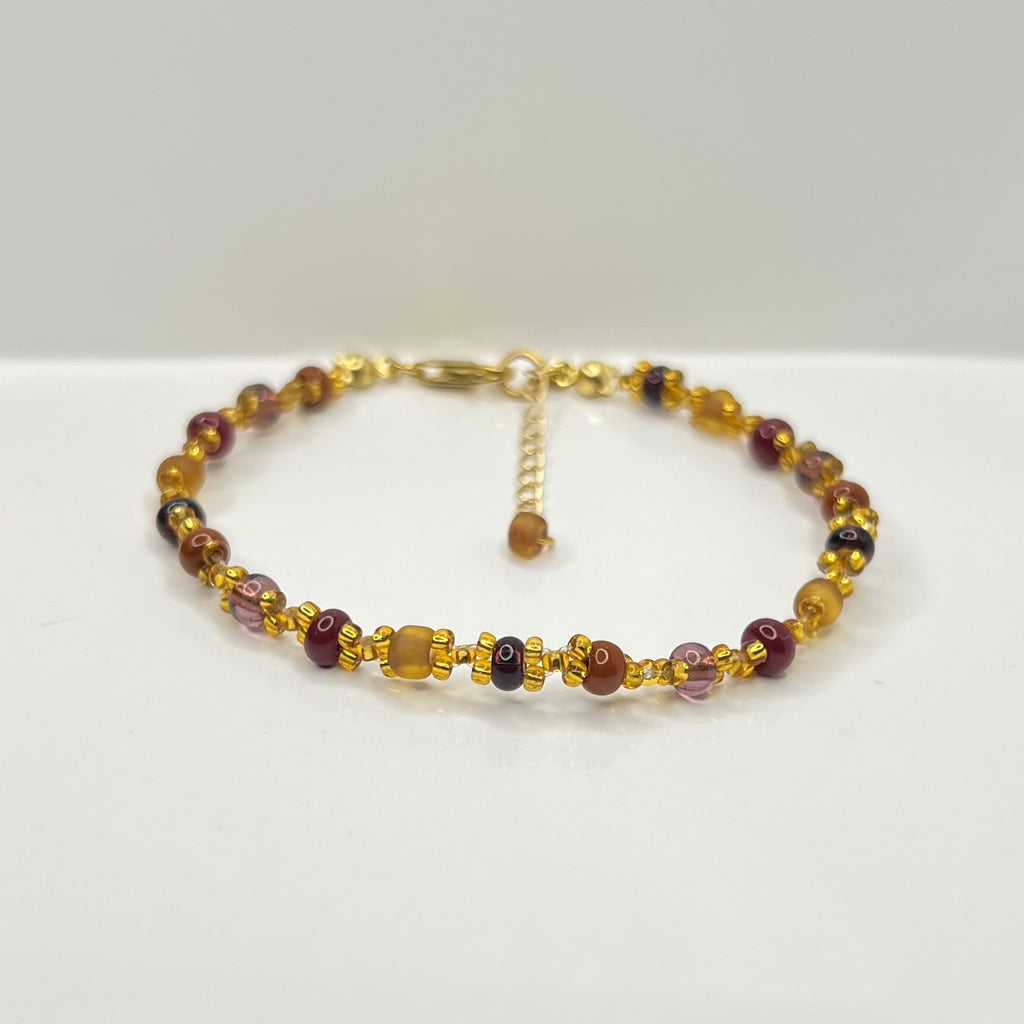 Beaded bracelet with gold accents on a white background