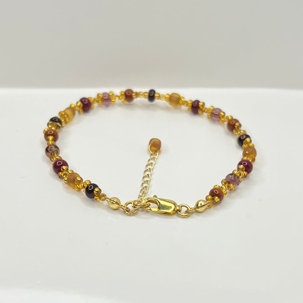 Gold bracelet with beads on a white background