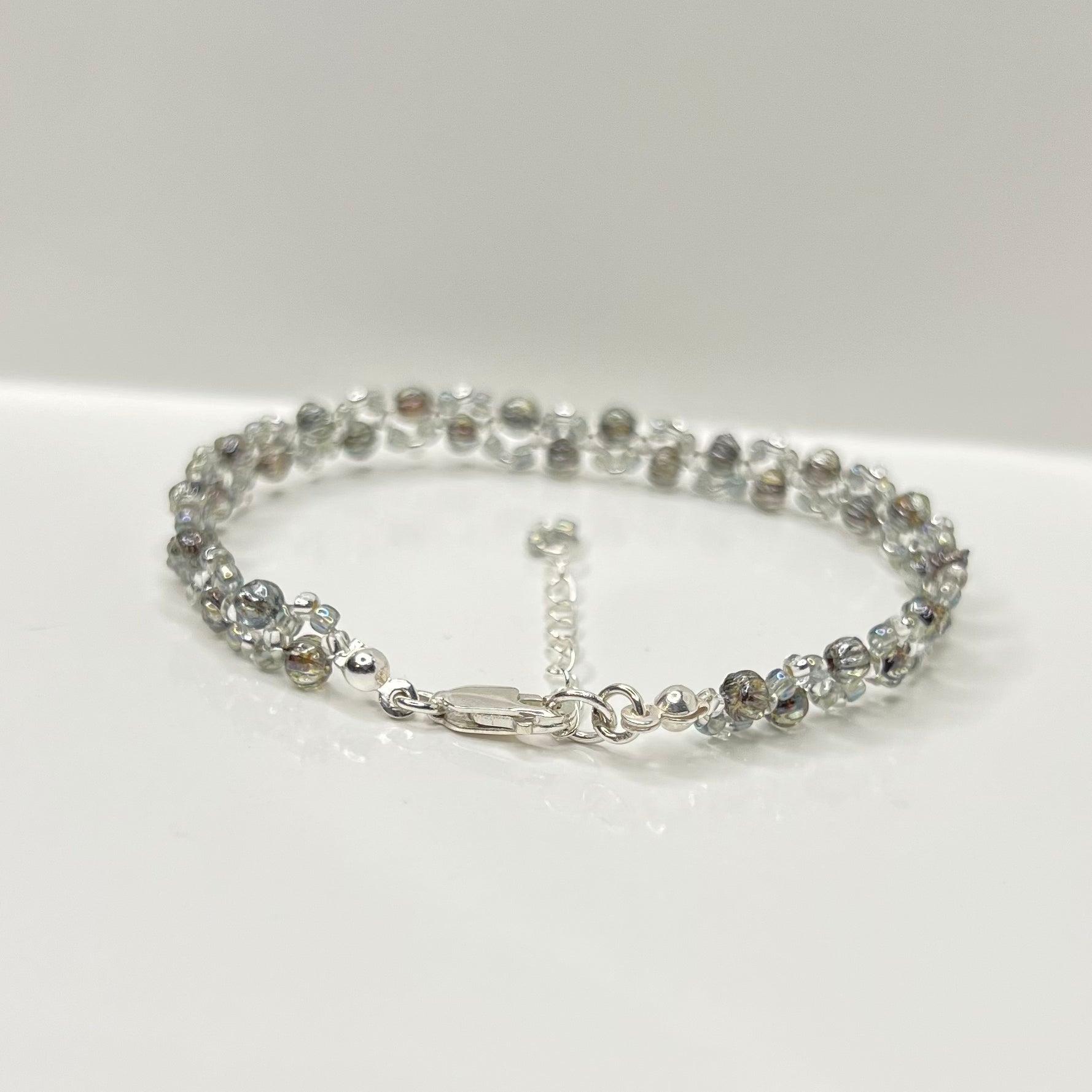 Silver bracelet with clear stones on a white background
