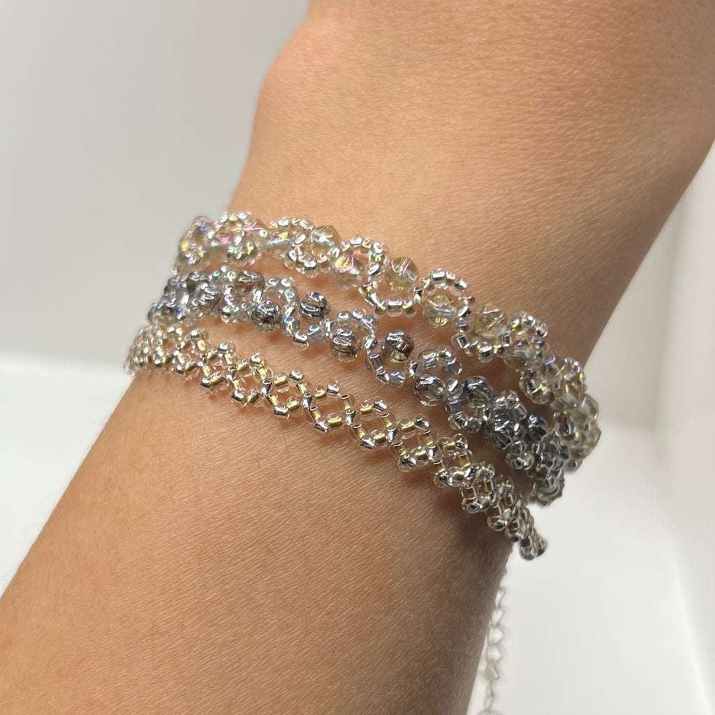 Silver beaded bracelet with clear stones on a wrist against a white background