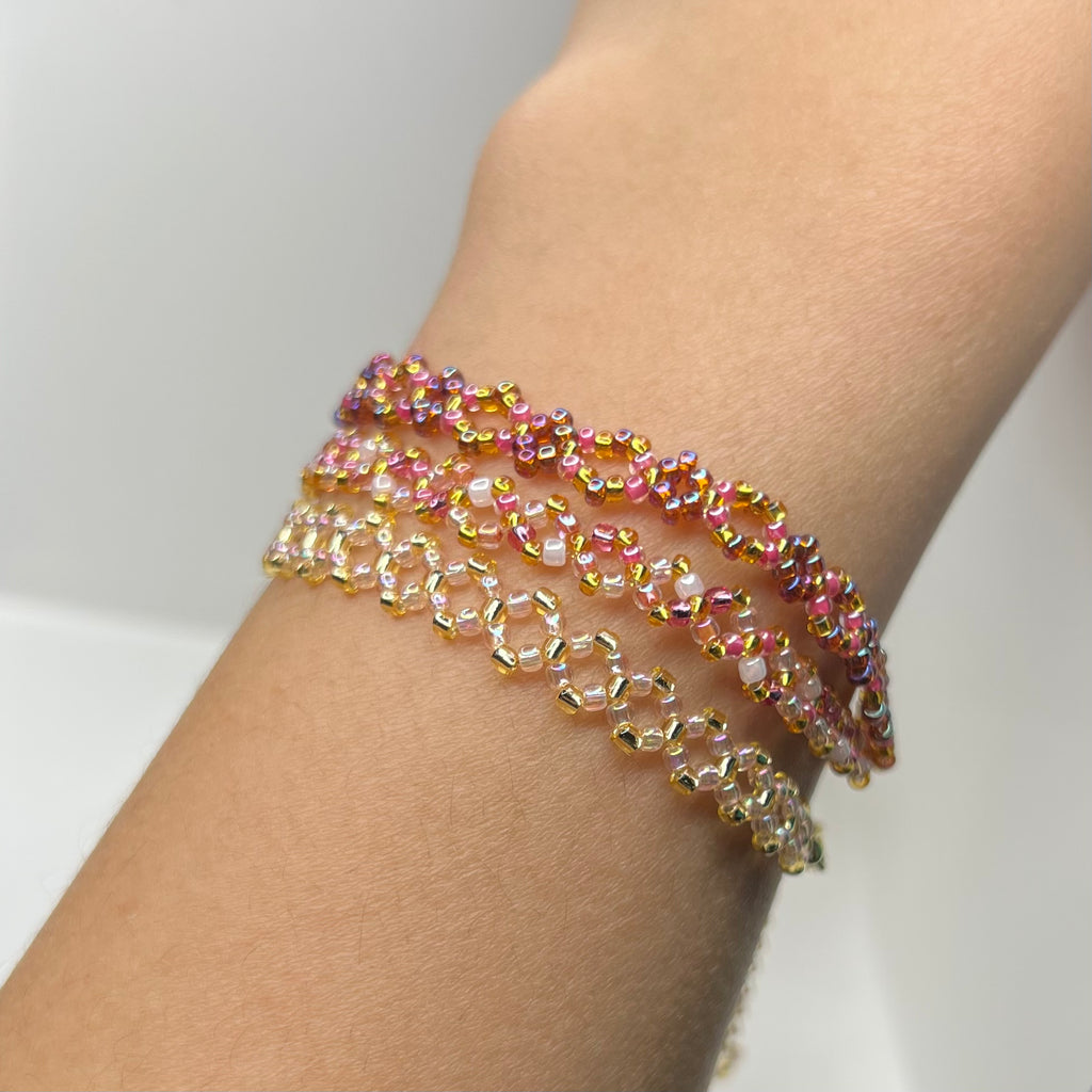 Multicolored beaded bracelet on a wrist against a neutral background